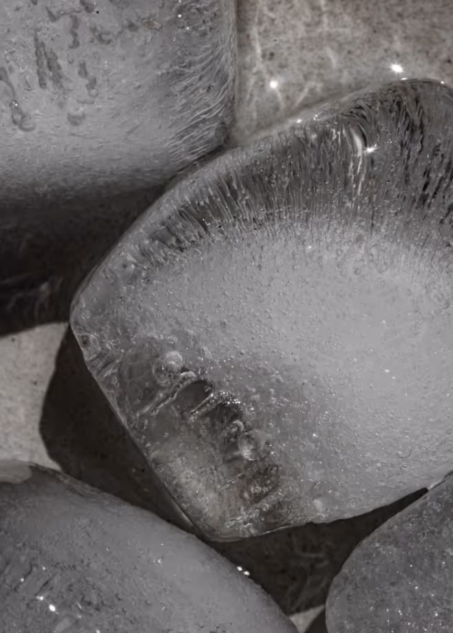 Extreme macro of translucent ice or wet stones with bubbles and highlights, desaturated grey tones